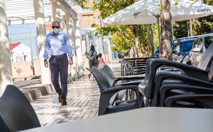 Un home camiña xunto á terraza dun bar. JAVIER POLBO - EUROPA PRESS / Europa Press