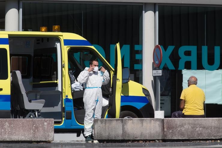 Un profesional sanitario baixa da ambulancia na que viaxa un paciente con Covid-19  