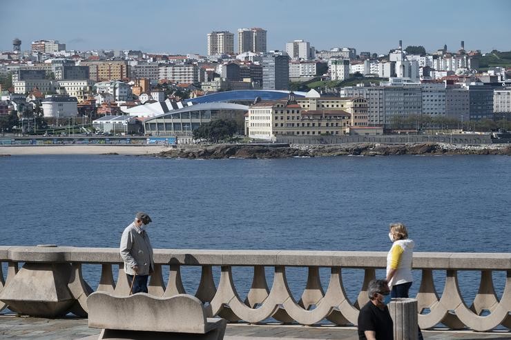 Dúas persoas pasean polo paseo marítimo da Coruña (Galicia), co estadio de Riazor de fondo, no segundo día en que o Goberno permite saír a facer deporte de forma individual e pasear con outra persoa coa que se conviva, a determinadas hora 