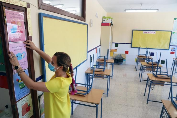 Unha profesora coloca carteis de medidas preventivas ante o COVID-19 na aula. Álex Zea - Europa Press