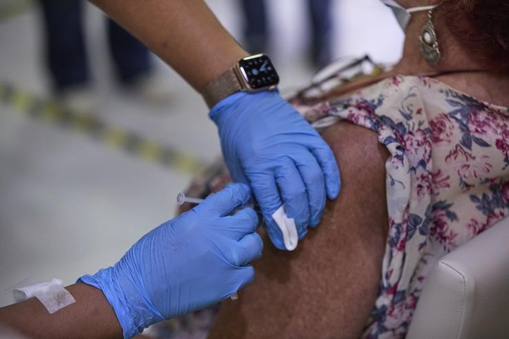 Unha sanitaria vacina a unha muller coa terceira dose da covid-19, na Residencia de Maiores Vista Alegre, a 22 de setembro de 2021, en Madrid 
