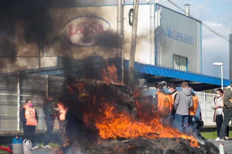 Unha fogueira durante unha acción sindical ante a planta de Larsa para esixir uns 'prezos xustos' para a produción de leite, a 16 de novembro de 2021, en Outeiro de Rei, Lugo 