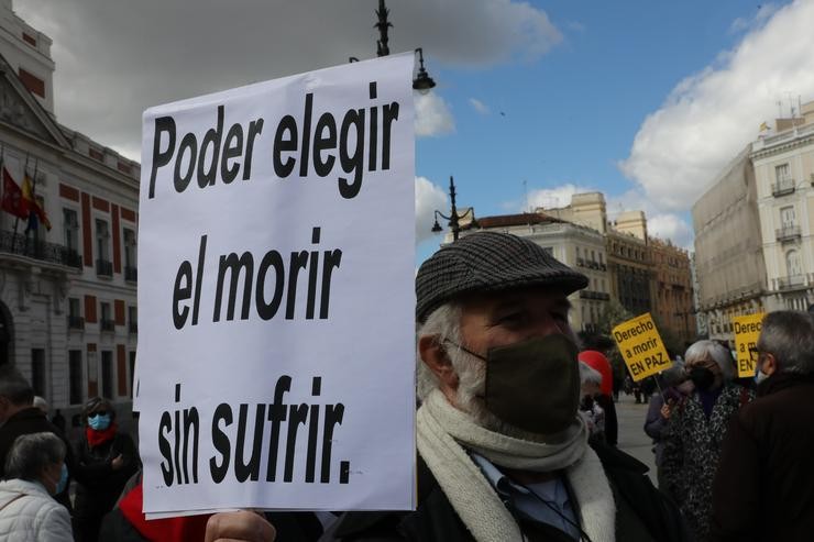 Un home cun cartel no que se le: `Poder elixir o morrer sen sufrir´ durante unha concentración de Dereito a Morrer Dignamente na Porta do Sol, en Madrid (España), a 18 de marzo de 2021 