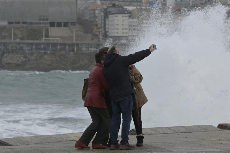 Un grupo de persoas fai, sen ter en conta as alertas, unha fotografía na zona das Escravas, na Coruña, durante unha borrasca e forte ondada no mar / M. Dylan - Europa Press