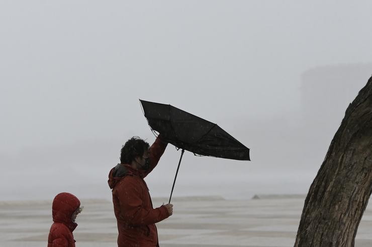 Dúas persoas camiñan na Coruña con chuvia e vento durante o paso dunha borrasca / M. Dylan - Arquivo