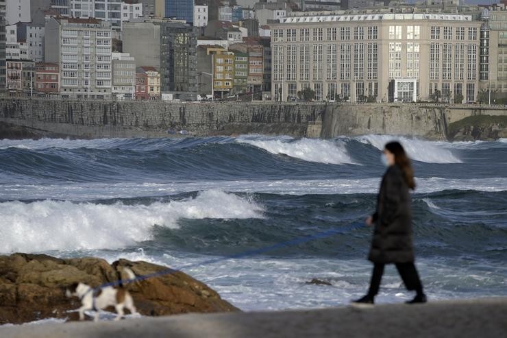 Unha muller pasea ao seu can no Paseo Marítimo da Coruña onde se aprecia forte ondada como consecuencia da borrasca Varra. M. Dylan - Europa Press / Europa Press