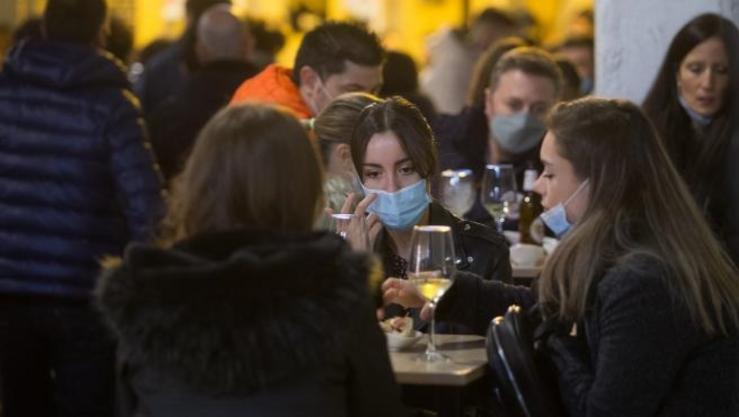 Un grupo de persoas toma consumicións nunha terraza 