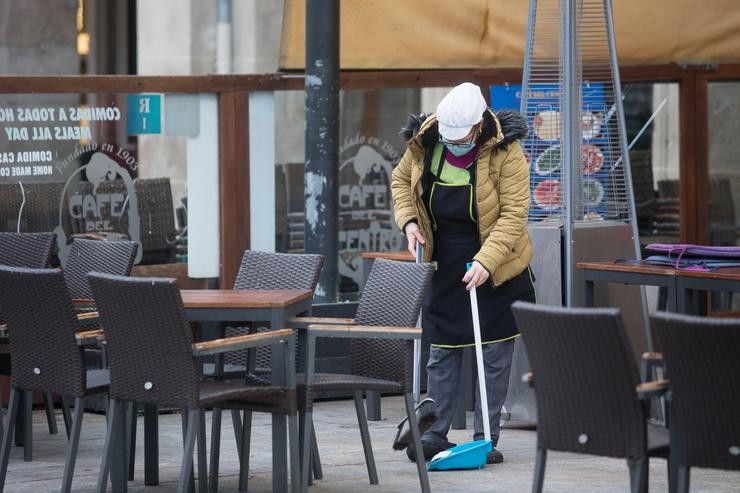 Unha muller varre a terraza dun restaurante o primeiro día do peche perimetral decretado en Lugo 