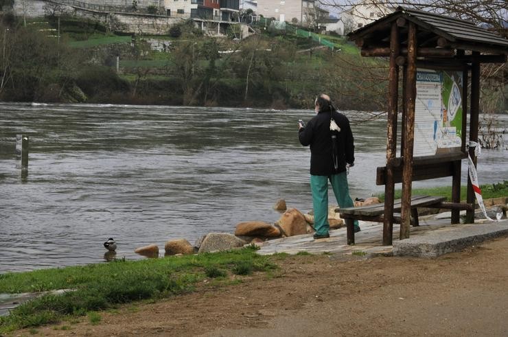 Unha persoa realiza unha fotografía ao río Miño que alagou a zona do paseo de Ou Tinteiro e a zona termal a Chavasqueira de Ourense, Galicia (España), a 11 de febreiro de 2021. Rosa Veiga - Europa Press / Europa Press
