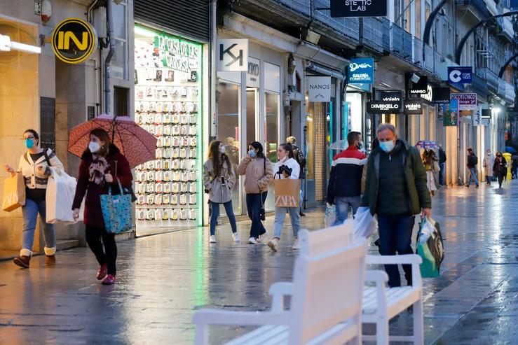 Varias persoas pasean nunha rúa comercial nunha xornada marcada polo inicio da entrada en vigor dunha desescalada gradual na rexión, en Vigo, Galicia (España), a 17 de febreiro de 2021.. Marta Vázquez Rodríguez - Europa Press 