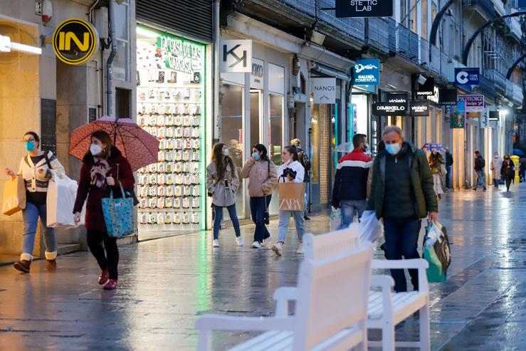 Varias persoas pasean nunha rúa comercial nunha xornada marcada polo inicio da entrada en vigor dunha desescalada gradual na rexión, en Vigo, Galicia (España), a 17 de febreiro de 2021.. Marta Vázquez Rodríguez - Europa Press / Europa Press