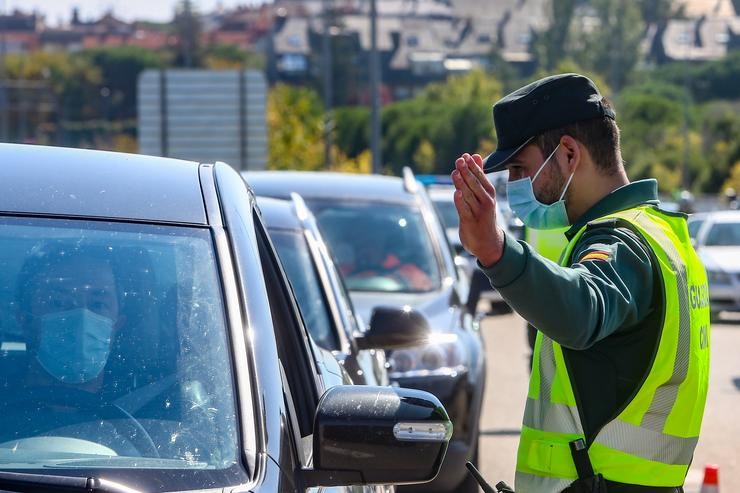 Un axente da Garda Civil dá o alto a un vehículo nun control dentro das medidas de prevención da Covid-19 