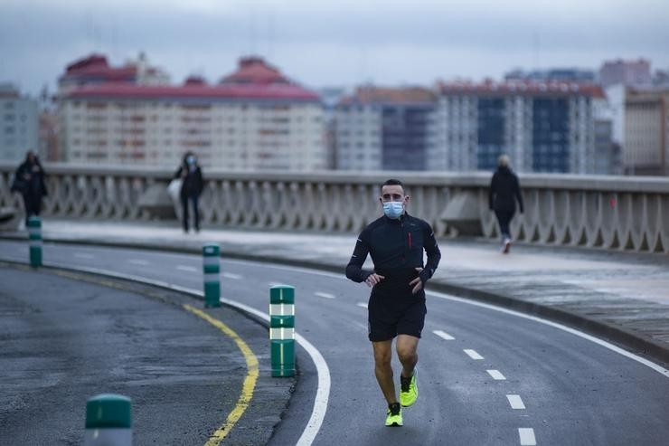 Unha persoa corre en solitario e con máscara no paseo marítimo da Coruña. M. Dylan - Europa Press