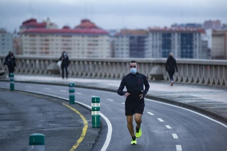 Unha persoa corre en solitario e con máscara un día despois da entrada en vigor da normativa que obriga aos deportistas a facer deporte ao aire libre con máscara e sen compañía en Galicia. M. Dylan - Europa Press 