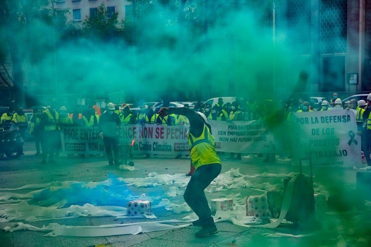 Traballadores da factoría pontevedresa de ENCE concéntranse con chalecos amarelos, pancartas, tirando rolos de papel hixiénico e rodeados de fume verde nas inmediacións do Ministerio de Transición Ecolóxica en Madrid, a 12 de marzo de 2021 