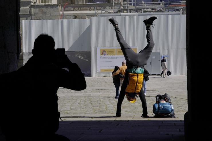 Un peregrino fotográfase saltando na Catedral de Santiago durante a ponte de San José.. Álvaro Ballesteros - Europa Press 