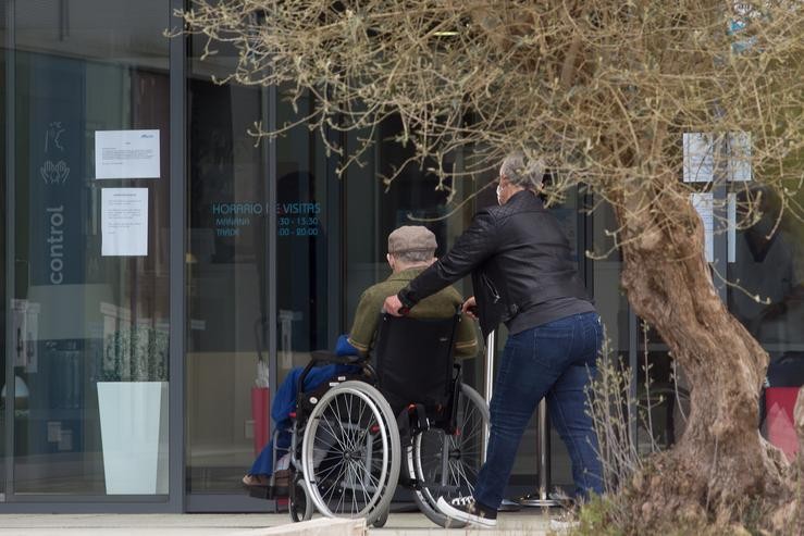 Unha muller pasea xunto a un ancián en cadeira de rodas cara á residencia Albertia, a 17 de abril de 2021, en Lugo, Galicia (España). Unha das novas medidas incluídas na desescalada de Galicia consiste na ampliación das posibilidades de visita. Carlos Castro - Europa Press 