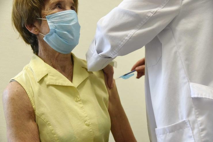 Unha sanitaria vacina a unha muller maior de 80 anos coa dose de Moderna no hospital Álvaro Cunqueiro de Vigo / Europa Press.