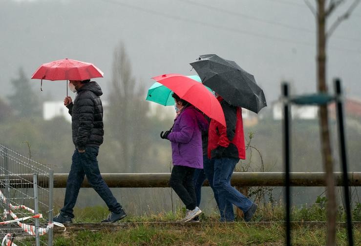 Arquivo - Varias persoas refúxianse cun paraugas da choiva en Vitoria, País Vasco (España), a 19 de marzo de 2021. Para a xornada de hoxe, está activado o aviso amarelo por baixo dos 1.000 metros e haberá precipitacións débiles moderadas. A. Pablo González - Europa Press - Arquivo