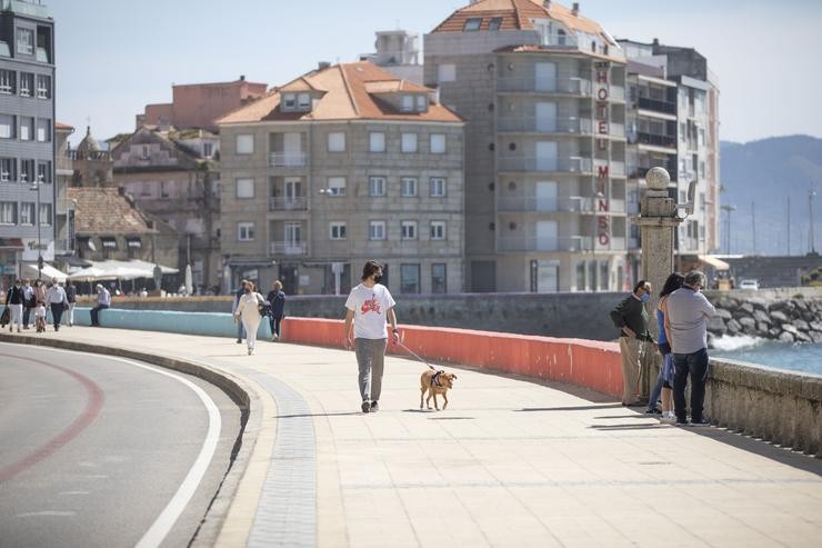 Varias persoas pasean polo Paseo Marítimo de Sanxenxo, en Pontevedra, Galicia (España), a 27 de marzo de 2021.. Beatriz Ciscar - Europa Press 
