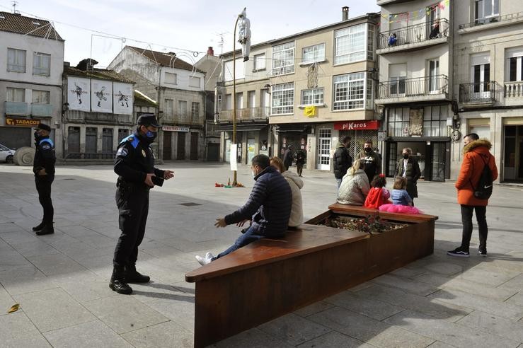 Arquivo - Axentes da Policía Local de Xinzo de Limia e veciños na praza Maior adornada co "Meco" tradicional de Entroido galego, en Xinzo de Limia, pertencente ao 