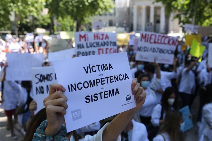 Unha persoa suxeita un cartel no que se le: 'Vítima da incompetencia do sistema', na manifestación convocada pola plataforma FSE Unida como protesta ao sistema de adxudicación de prazas MIR fronte ao Ministerio de Sanidade 