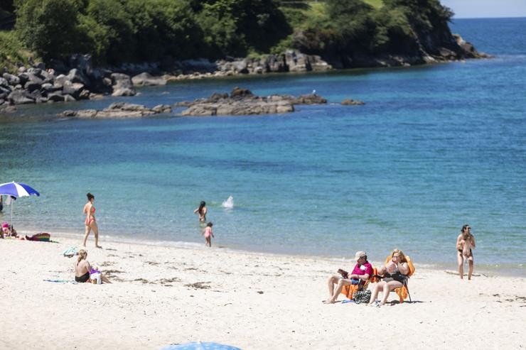 Varias persoas báñanse e toman o sol nunha praia do municipio de Marín (Pontevedra).. Beatriz Ciscar - Europa Press / Europa Press