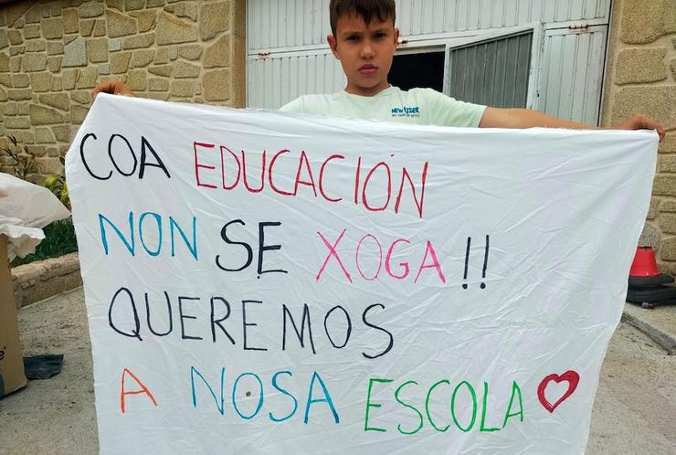 Unha crianza sostén un cartel contra o recorte de recursos na súa escola / Que Pasa na Costa