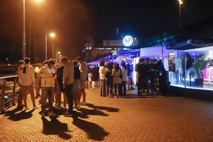 Varios mozos nun dos locais de lecer nocturno do Porto de Sanxenxo, a 3 de xullo de 2021, en Pontevedra, Galicia (España). As autoridades poden chegar a multar e mesmo, clausurar os establecementos se non se cumpren as novas medidas Covid. Marta Vázquez Rodríguez - Europa Press 