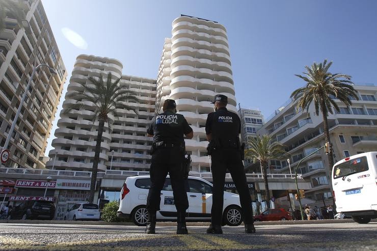 Dous policías locais fan garda fronte ao hotel Palma Bellver, onde estaban confinados 249 mozos que tiveron relación directa ou indirecta co brote dunha viaxe de estudos a Mallorca, a 30 de xuño de 2021. Isaac Buj - Europa Press 