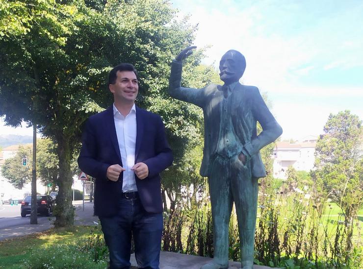 O secretario xeral do PSdeG, Gonzalo Caballero, fronte á estatua do fundador do Partido Socialista, Pablo Igrexas, nun parque de Santiago de Compostela 