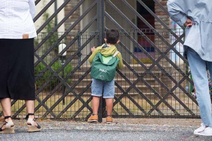 Un neno asómase ás portas do CEIP Manuel Mallo de Nadela, durante o primeiro día do curso escolar 2021-2022 / Carlos Castro - Europa Press