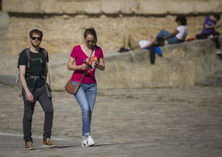 Arquivo - Dúas persoas camiñando por Sevilla nun día de subida de temperaturas. María José López - Europa Press - Arquivo