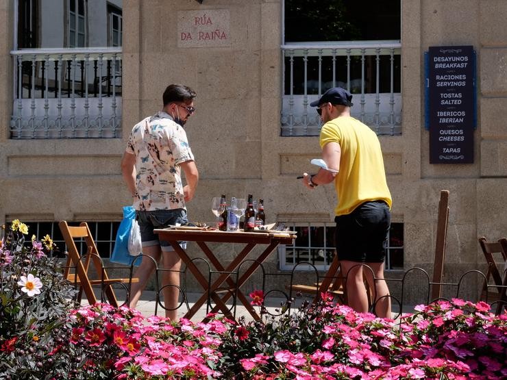 Dous homes abandonan unha terraza dun restaurante da Rua dá Raiña, a 12 de agosto de 2021, en Santiago de Compostela. César Arxina - Europa Press / Europa Press