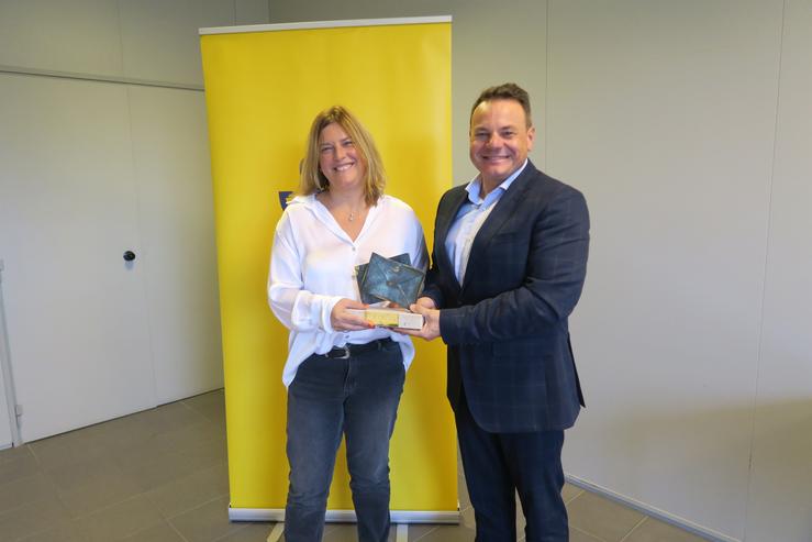 A responsable do centro loxístico de Santiago de Correos, María Dolores Blanco, recibe de man do xerente de Produción de Correos, José Ángel del Río Tembrás,  o premio de excelencia de 2021 / Correos - Europa Press