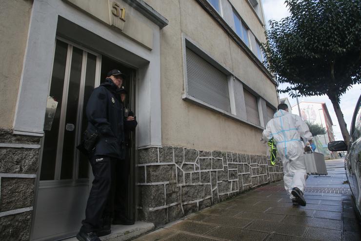 Un axente de Policía Nacional na porta da vivenda onde acharon morta a unha muller de 42 anos.. Carlos Castro - Europa Press