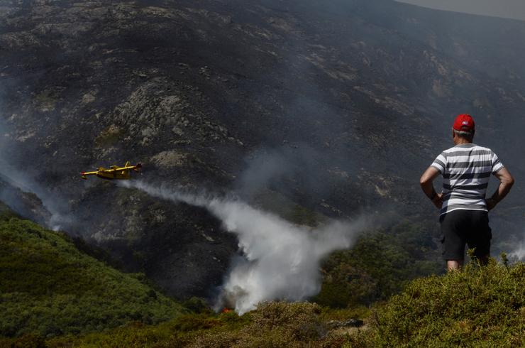 Un veciño de Senderiz en Lobeira observa un hidroavión traballar no incendio forestal na Serra do Leboreiro, no parque natural de Baixa Limia e Serra do Xurés / Rosa Veiga - Arquivo