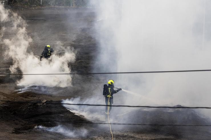 Dous bombeiros traballan na extinción do lume da antiga fábrica de Pontesa, en Ponte Sampaio 