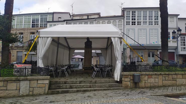 Estatua de Curros Enríquez cuberta por unha carpa en Celanova 