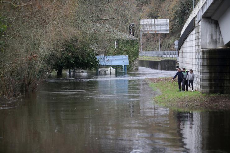 Varias persoas observan a crecida do río Miño debido ás choivas, en Lugo, a 25 de decembro de 2022 