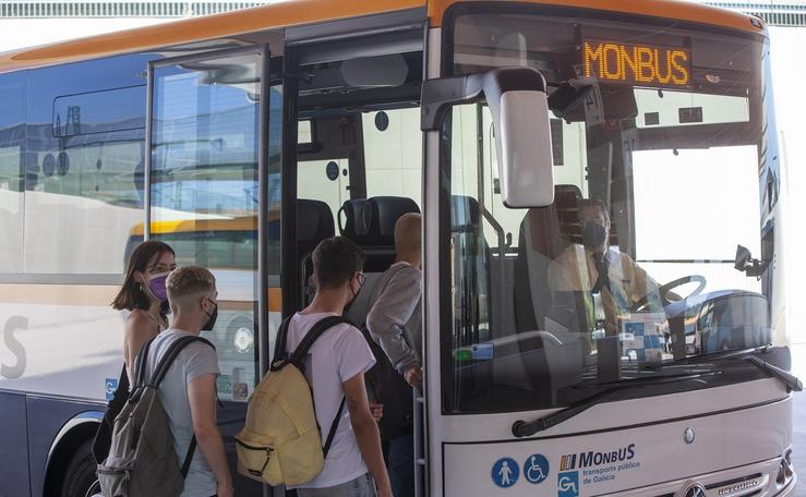 Viaxeiros subíndose a un autobús da compañía Monbus