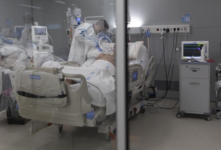 Un sanitario atende un paciente con covid-19 ingresado na UCI do Hospital Isabel Zendal de Madrid / Eduardo Parra - Europa Press.