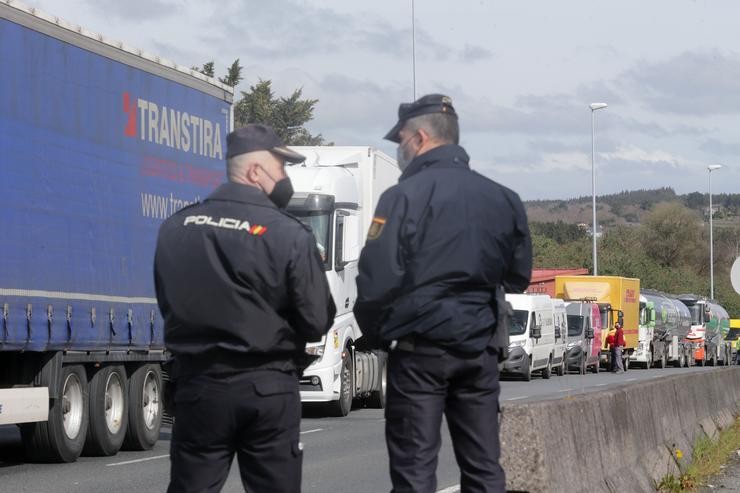 Dous axentes de Policía Nacional observan os camións parados na beiravía nun dos accesos ao Polígono de Ou CEAO, nunha folga indefinida do transporte de mercadorías, a 14 de marzo de 2022, en Lugo, Pontevedra (España). O paro, convocado a nivel n. Carlos Castro - Europa Press / Europa Press