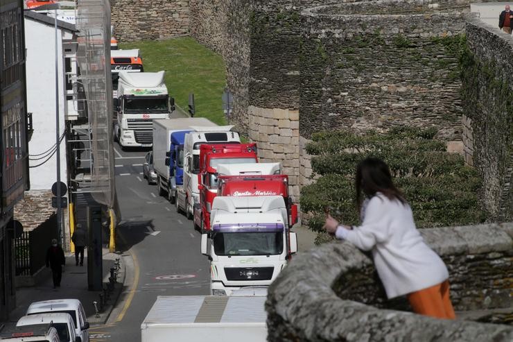 Unha muller observa o paso dos camións desde o adarve da Muralla, nunha marcha lenta que saíu desde o polígono das Gándaras para pasar por varias localizacións do centro da cidade, durante o noveno día de paro nacional de transportis. Carlos Castro - Europa Press