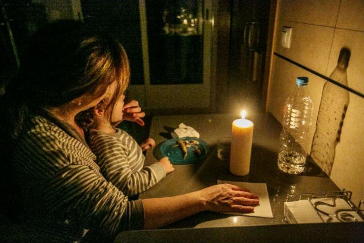 Unha muller e a súa crianza cean á luz dunha vela / Arquivo