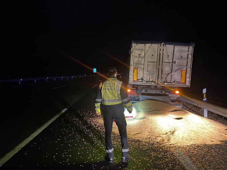 A Garda Civil acode pola caída de parte do millo que transportaba un camión na A-6 en Baralla (Lugo).. GARDA CIVIL / Europa Press