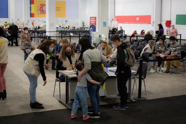 Un neno refuxiado ucraíno con voluntarias tradutoras, no centro de refuxiados ucraínos, na Fira de Barcelona, a 8 de abril de 2022, en Barcelona. David Zorrakino - Europa Press / Europa Press