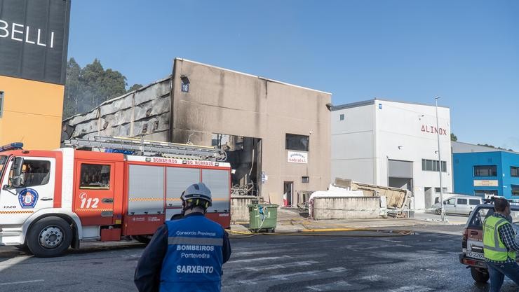 Un bombeiro observa as instalacións da nave industrial de poliéster onde se produciu un incendio que a deixou calcinada, a 10 de maio de 2022, en Bueu (Pontevedra).. Gustavo da Paz - Europa Press / Europa Press