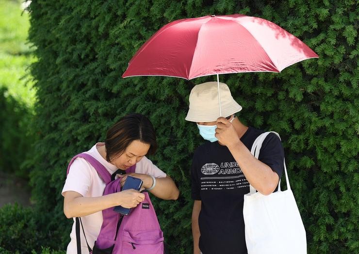 Dous turistas cun paraugas para refuxiarse da calor/ Eduardo Parra - Europa Press