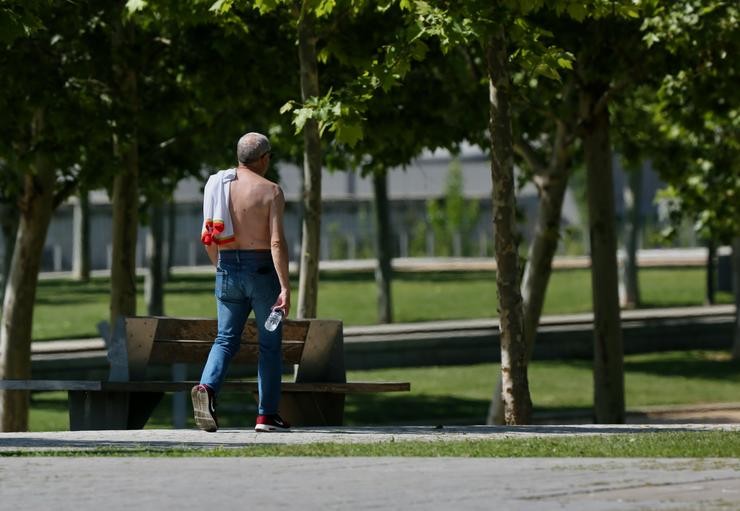 Un home camiña sen camiseta o día en que España comezou a sufrir un "importante" episodio cálido con temperaturas de pleno verán / Cézaro De Luca - Europa Press